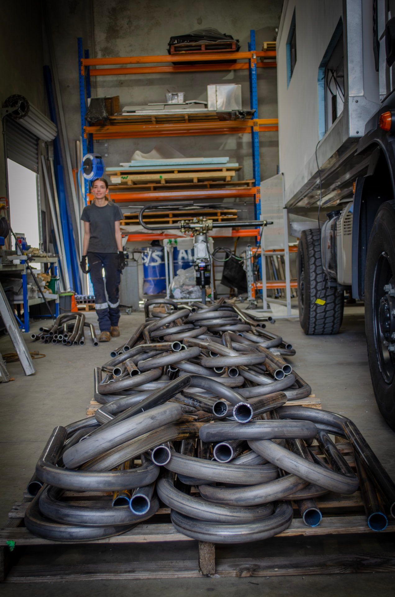 Inside the MiWeld fabrication workshop in Malaga, Perth, with pallets of mandrel-bent steel tube